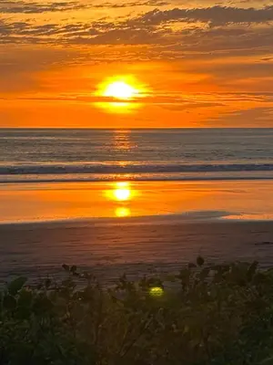 a sunset on the beach with the sun setting at Matata in San Juanillo