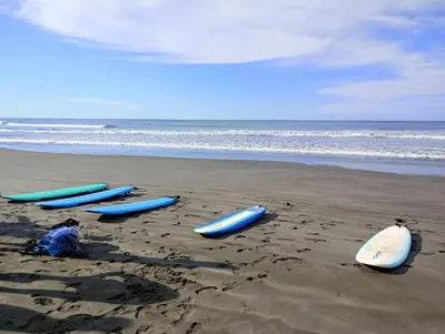 four surfboards are lined up on a beach at Matata in San Juanillo