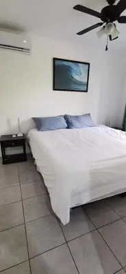 a bedroom with a white bed with a ceiling fan at Matata in San Juanillo