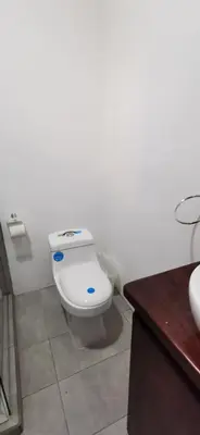 a bathroom with a white toilet and a sink at Matata in San Juanillo