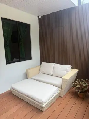 a wicker chair and a ottoman in a room at Matata in San Juanillo