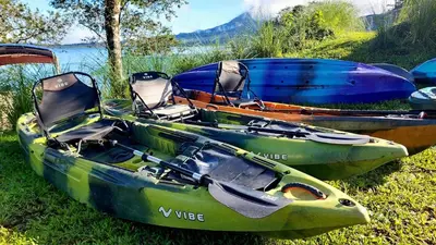 three boats sitting on the grass near the water at Rustico Villa Arenal in Fortuna