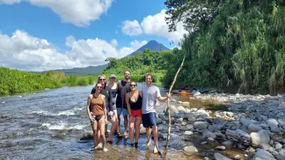 a group of people standing in a river at Rustico Villa Arenal in Fortuna