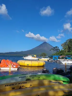 a group of boats in the water with a mountain in the background at Rustico Villa Arenal in Fortuna