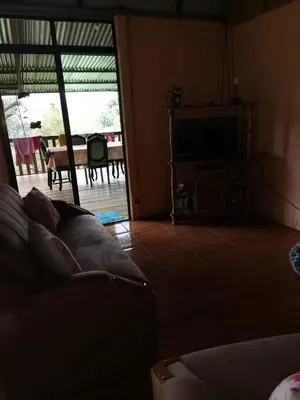 a living room with a couch and a flat screen tv at Bella Vista Guest house in Turrialba