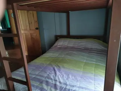 a bedroom with a bunk bed and a ladder at Bella Vista Guest house in Turrialba