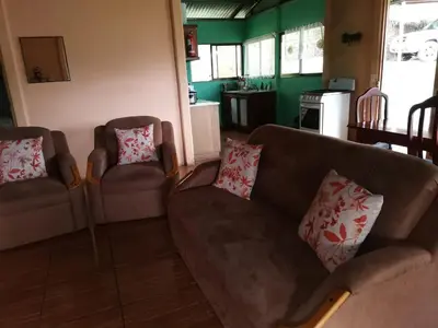 a living room with a couch and two chairs at Bella Vista Guest house in Turrialba