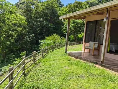 a porch of a house with a bench on the grass at Papaturro House in La Cruz