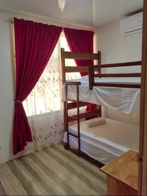 a bedroom with two bunk beds and a window at Papaturro House in La Cruz