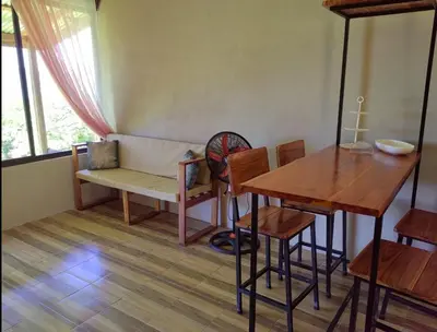a room with a table and a couch and a table and chairs at Papaturro House in La Cruz