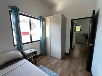 a bedroom with a bed and a door to a bathroom at Peaceful Apartment in Tamarindo, 50m to the Beach - Sofia Apartments in Tamarindo