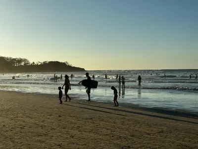 a group of people walking on the beach at Peaceful Apartment in Tamarindo, 50m to the Beach - Sofia Apartments in Tamarindo