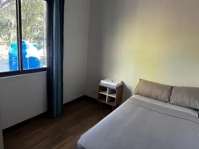 a small room with a bed and a window at Peaceful Apartment in Tamarindo, 50m to the Beach - Sofia Apartments in Tamarindo