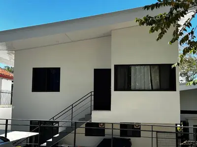 a white building with two windows and a staircase at Peaceful Apartment in Tamarindo, 50m to the Beach - Sofia Apartments in Tamarindo