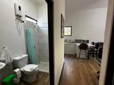 a bathroom with a toilet and a shower and a kitchen at Peaceful Apartment in Tamarindo, 50m to the Beach - Sofia Apartments in Tamarindo