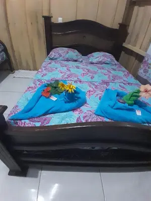 a bed with two blue towels on it at Los Paniquines Ecolodge in Drake