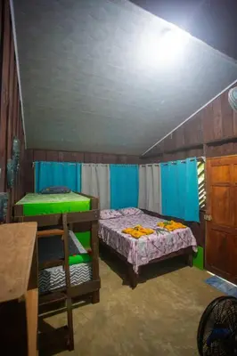 a room with two bunk beds and a table at Los Paniquines Ecolodge in Drake
