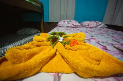 a bed with yellow towels on top of it at Los Paniquines Ecolodge in Drake