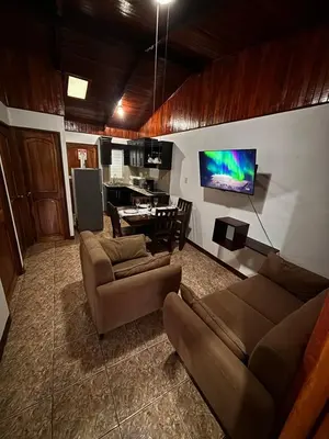 a living room with a couch and a dining room at Apartamentos Maily in Fortuna