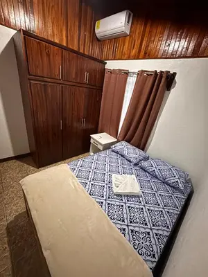 a bedroom with a bed with a blue and white bedspread at Apartamentos Maily in Fortuna