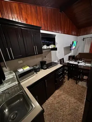 a kitchen with wooden cabinets and a dining room at Apartamentos Maily in Fortuna
