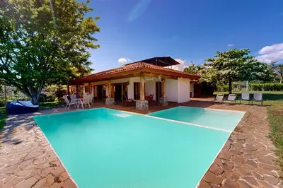 a swimming pool in front of a house at Finca de La Luna in Atenas