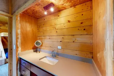 a bathroom with a sink and a wooden wall at Finca de La Luna in Atenas