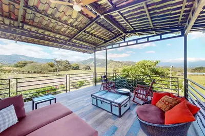 a living room with a couch and chairs on a deck at Finca de La Luna in Atenas