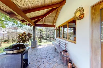 a porch with a bench and a clock on the wall at Finca de La Luna in Atenas