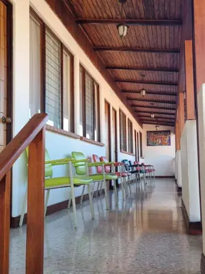 a row of green chairs in a hallway at Hotel La Siesta in Liberia