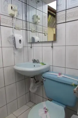 a bathroom with a sink and a toilet and a mirror at Hotel La Siesta in Liberia