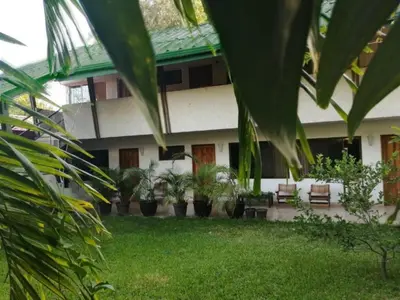 a building with a bunch of plants in a yard at Hotel El Bramadero in Liberia
