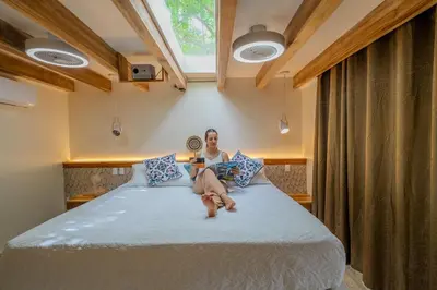 a woman sitting on a bed in a room at Dreamcatcher Hotel - Live the Dream of Santa Teresa in Santa Teresa Beach