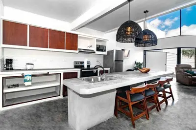 a kitchen with a large counter and chairs in it at Private pool & rooftop patio Hot tub, AC, WI-FI in Jacó
