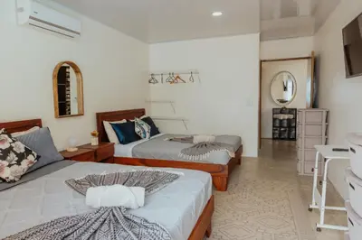 a bedroom with two beds and a mirror at Private pool & rooftop patio Hot tub, AC, WI-FI in Jacó