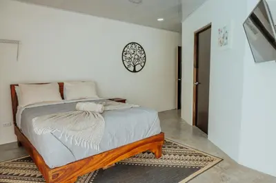 a bedroom with a bed and a clock on the wall at Private pool & rooftop patio Hot tub, AC, WI-FI in Jacó