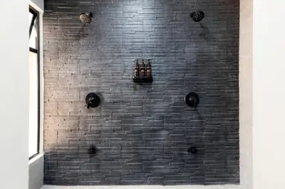 a shower with a black brick wall at Private pool & rooftop patio Hot tub, AC, WI-FI in Jacó