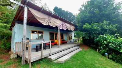 a small house with a large deck in the yard at Casa Monte Armadillo in Poás
