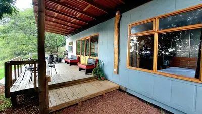 a porch of a blue house with a table and chairs at Casa Monte Armadillo in Poás
