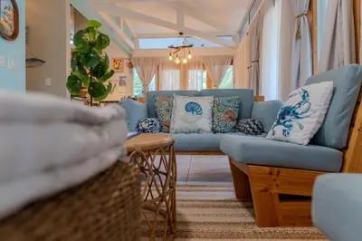 a living room with blue couches and a table at Casa Choucoune in Parrita