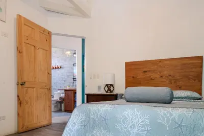 a bedroom with a bed with a wooden headboard at Casa Choucoune in Parrita