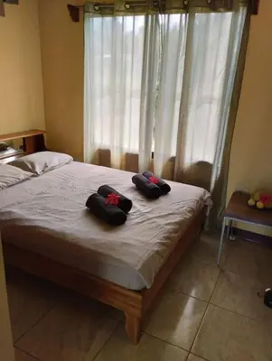a bedroom with a bed with two pillows on it at House in Cuajiniquil ,Belen de nosarita in Cuajiniquil