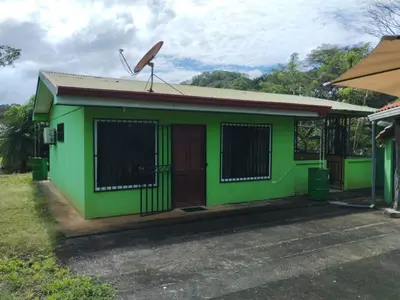 a green building with a sign on top of it at House in Cuajiniquil ,Belen de nosarita in Cuajiniquil