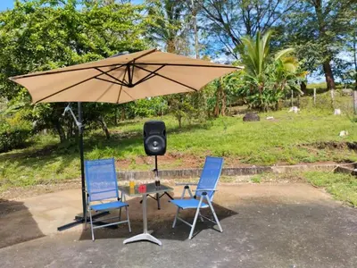 two chairs and an umbrella with a speaker at House in Cuajiniquil ,Belen de nosarita in Cuajiniquil