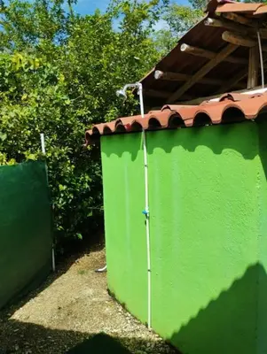 a green fence with a roof on top of it at House in Cuajiniquil ,Belen de nosarita in Cuajiniquil