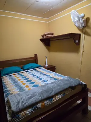 a bedroom with a bed with a lamp and a fan at Lodge Barka Lounge in Jabilla