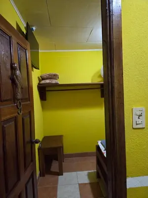 a room with a yellow wall and a wooden door at Lodge Barka Lounge in Jabilla
