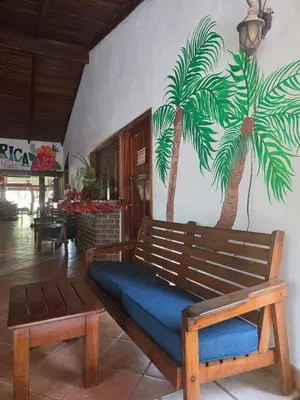a bench with a palm tree mural on a wall at Lodge Barka Lounge in Jabilla