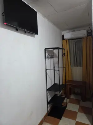 a room with a tv on the wall and a shelf at Lodge Barka Lounge in Jabilla