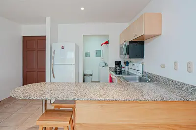 a kitchen with a counter top and a refrigerator at Palmas de Tamarindo 201D in Tamarindo